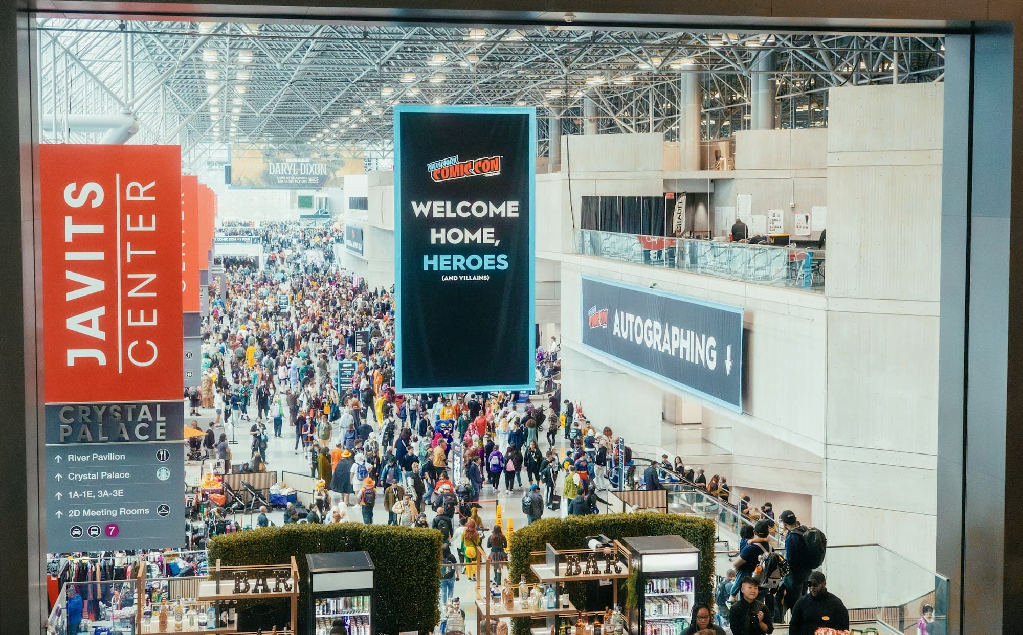 A crowded exhibition hall filled with visitors beneath a welcome banner