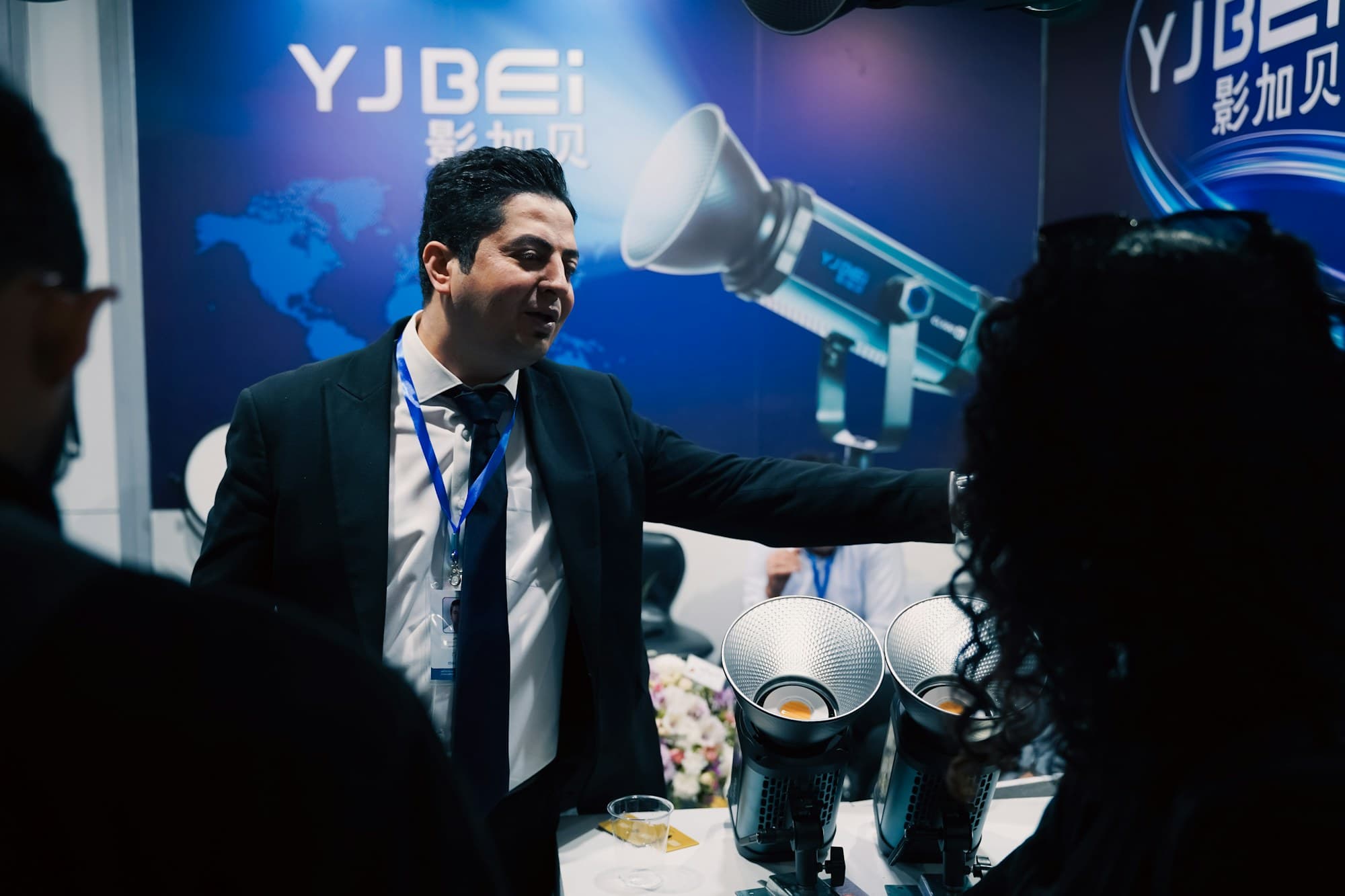 A presenter demonstrates equipment at a trade show booth